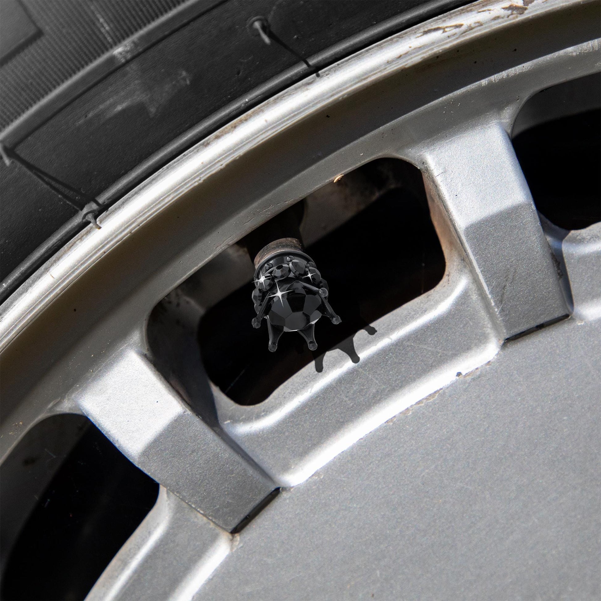 Black crown tire valve caps installed on car wheel
