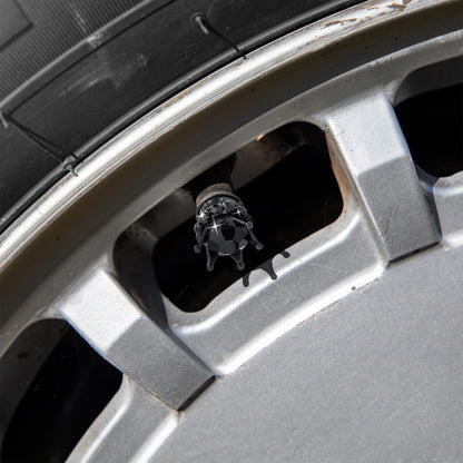 Black crown tire valve caps installed on car wheel
