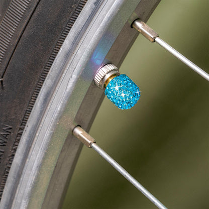 Blue rhinestone tire valve caps installed on bicycle tire valve stem
