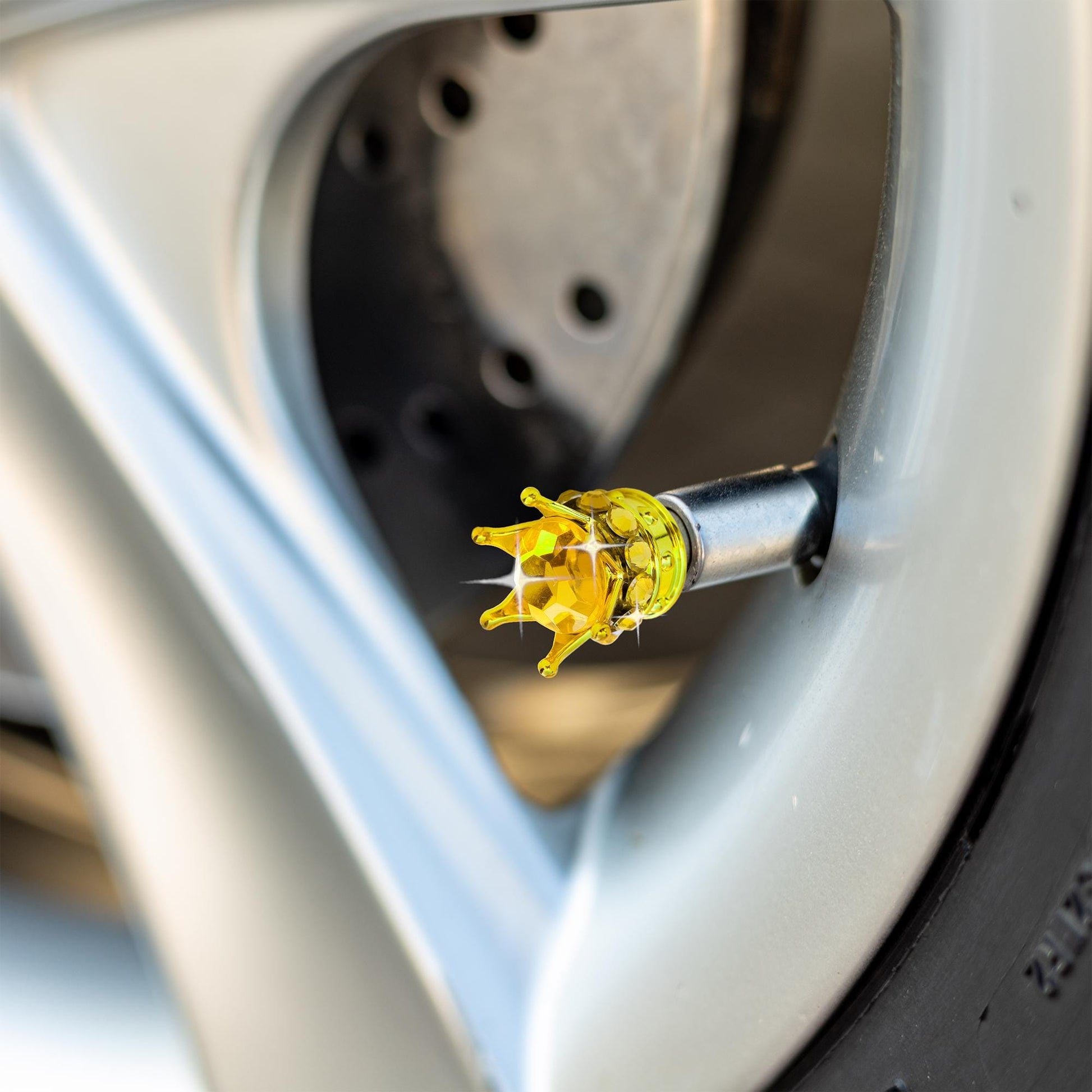 Gold crown tire valve caps installed on car wheel
