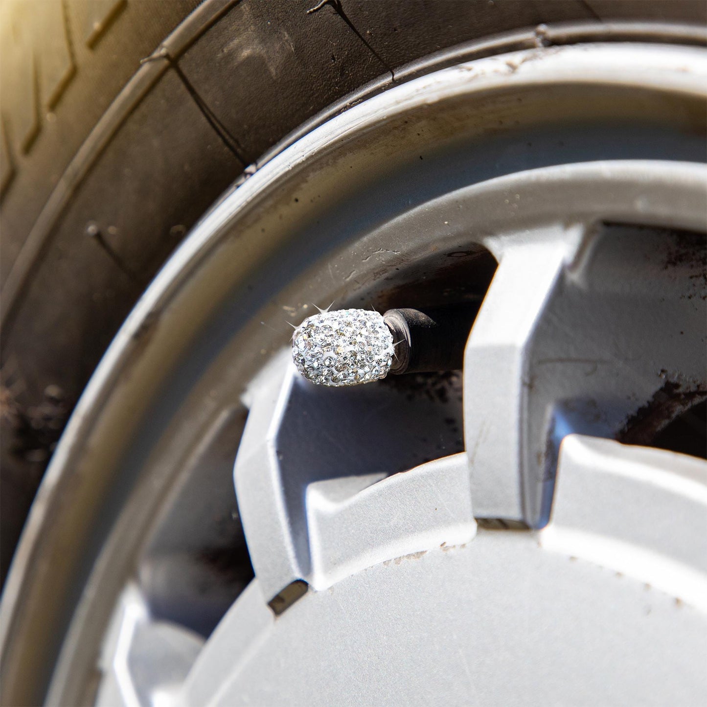 Rhinestone tire valve caps installed on car wheel for style upgrade