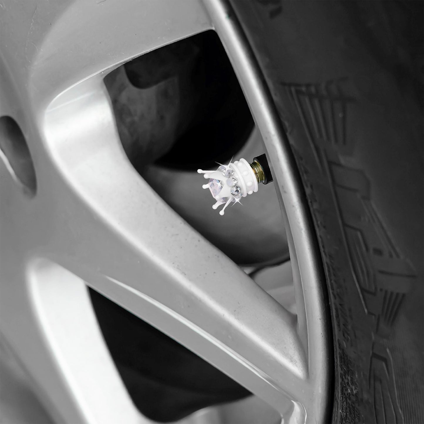 White crown tire valve caps installed on car wheel
