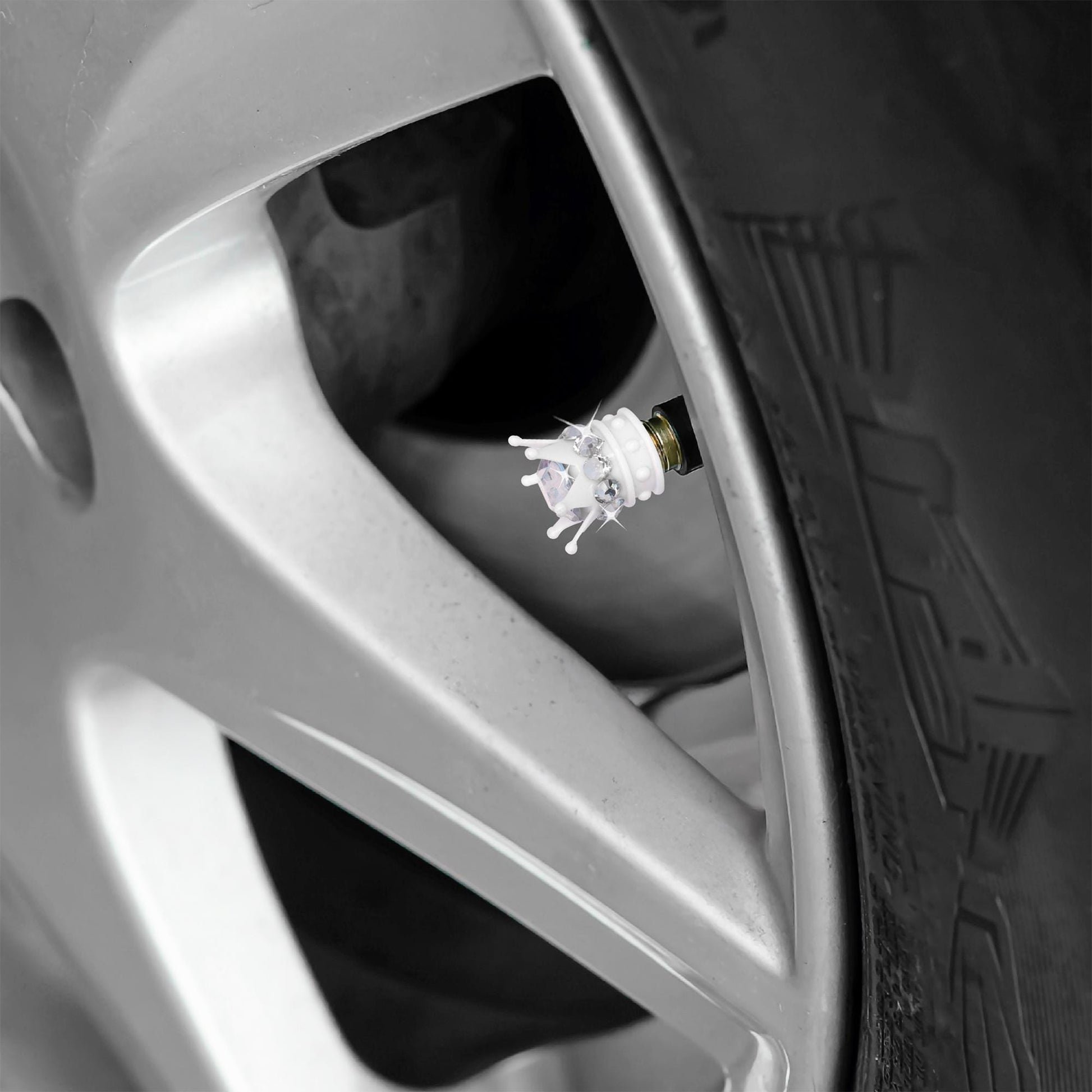 White crown tire valve caps installed on car wheel

